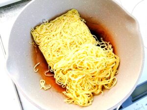 麺をフライパンで炒めている写真